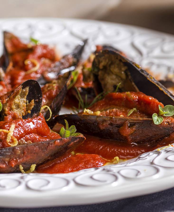 Stuffed mussels over a tomato reduction