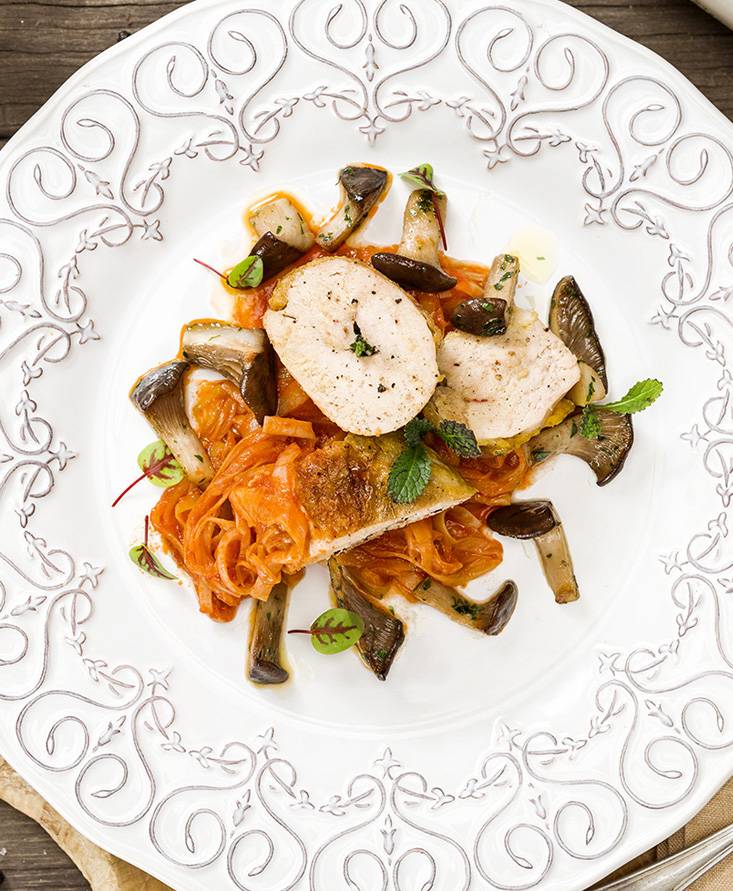 Guinea hen supreme with tomato-braised leeks and king oyster mushrooms sautéed in oil, garlic and parsley